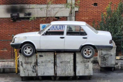 İşyerinin önünü kapatan aracı çöpe attılar