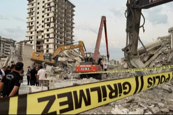 Kahramanmaraş'ta hasarlı bina, iş makinesinin üzerine devrildi! Operatör enkaz altında kaldı