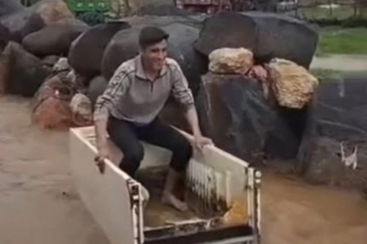 Mardin'de sel sularında buzdolabı kasasıyla ilerledi